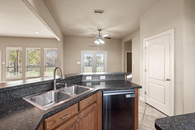 kitchen featuring light tile patterned floors, stainless steel dishwasher, a wealth of natural light, and sink