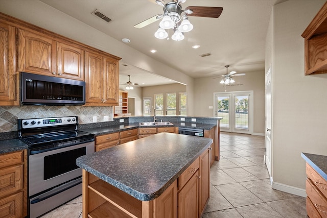 kitchen featuring decorative backsplash, a center island, kitchen peninsula, and stainless steel appliances