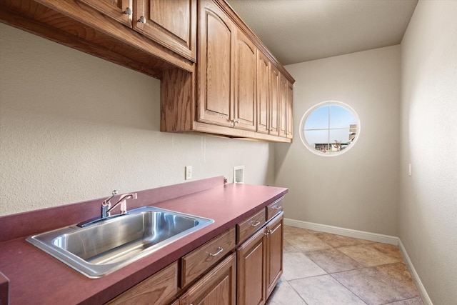 laundry area featuring cabinets, hookup for a washing machine, light tile patterned floors, and sink