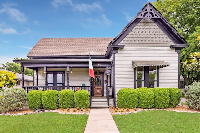 view of front of property with covered porch and a front yard