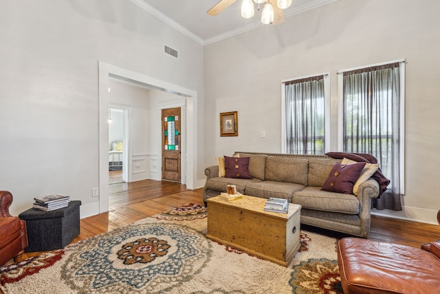 living room with ceiling fan, crown molding, high vaulted ceiling, and light wood-type flooring