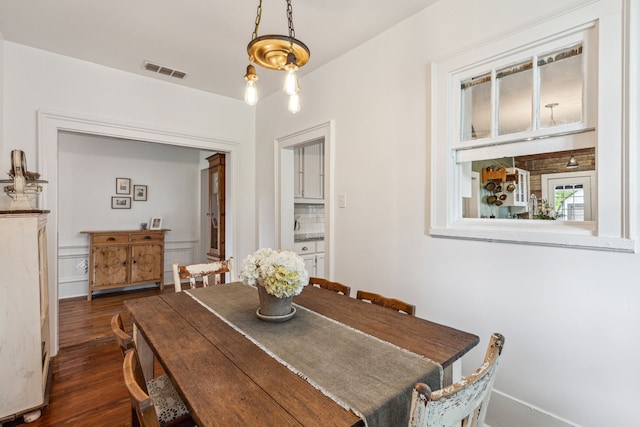 dining space featuring dark hardwood / wood-style floors and an inviting chandelier