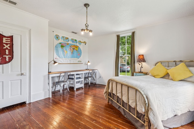 bedroom with a textured ceiling, dark hardwood / wood-style floors, and ornamental molding