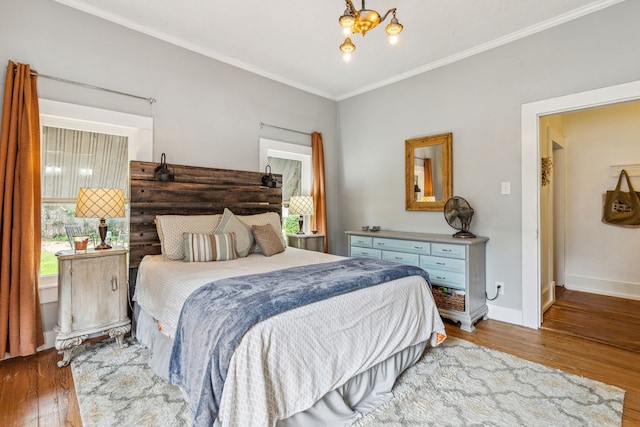 bedroom featuring hardwood / wood-style floors, a notable chandelier, and ornamental molding