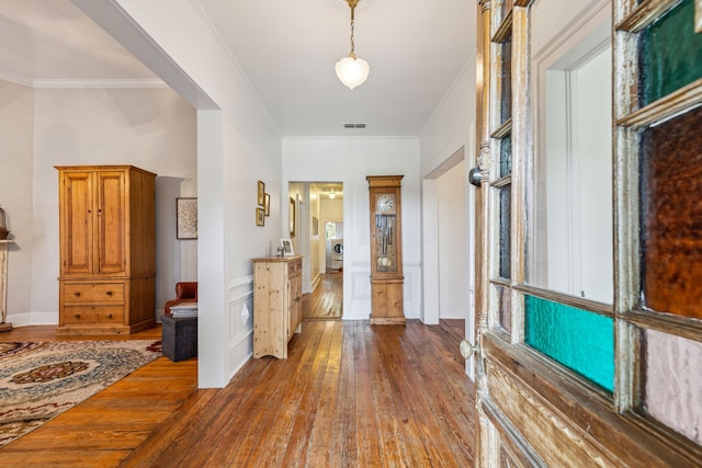 foyer entrance featuring dark hardwood / wood-style floors, washer / clothes dryer, and ornamental molding