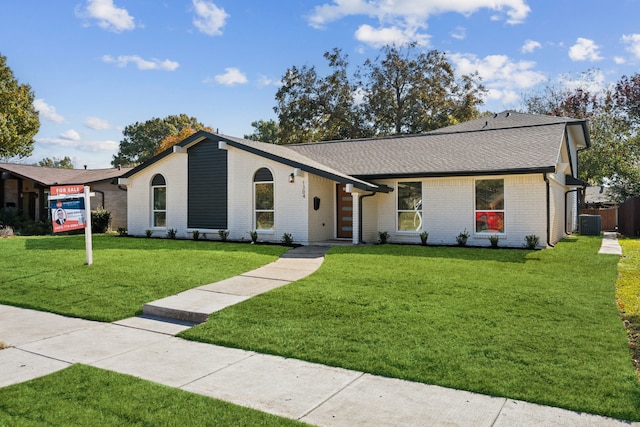 ranch-style house featuring cooling unit and a front lawn