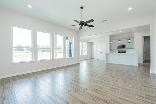 unfurnished living room featuring light hardwood / wood-style flooring and ceiling fan