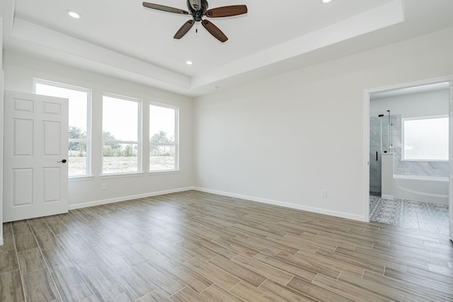 empty room with a raised ceiling and ceiling fan