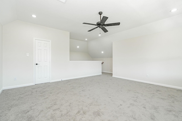 carpeted spare room with vaulted ceiling and ceiling fan