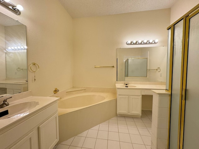 bathroom featuring tile patterned flooring, vanity, separate shower and tub, and a textured ceiling