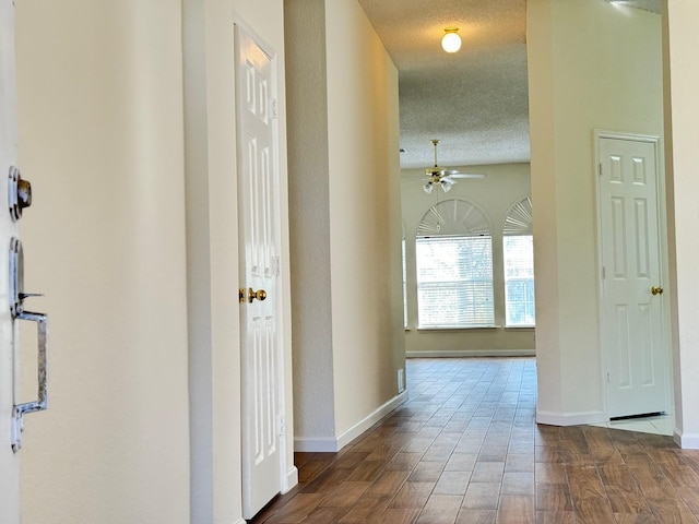 corridor with hardwood / wood-style flooring and a textured ceiling