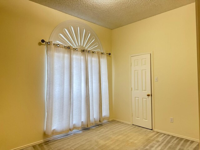 spare room with a textured ceiling and carpet floors