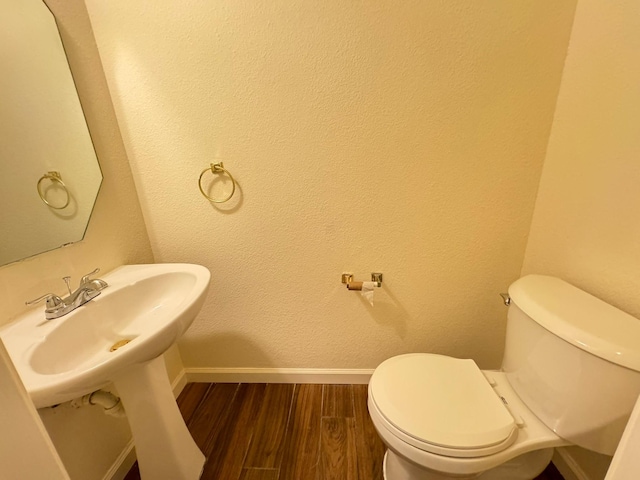 bathroom featuring hardwood / wood-style flooring and toilet