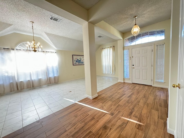 entryway with plenty of natural light, a chandelier, and light hardwood / wood-style floors