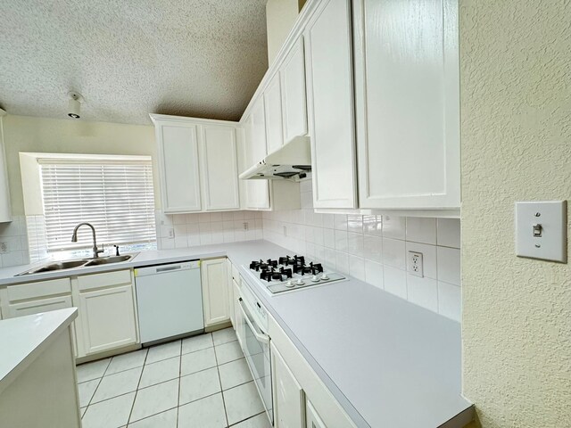 kitchen featuring white cabinets, a textured ceiling, white appliances, and sink