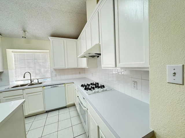 kitchen featuring tasteful backsplash, sink, white appliances, and white cabinets