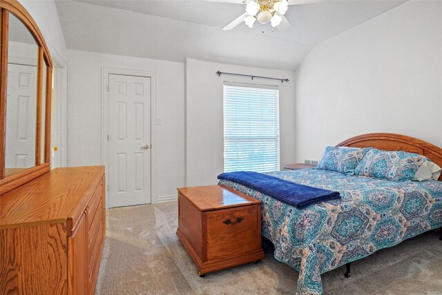 carpeted bedroom with ceiling fan and vaulted ceiling