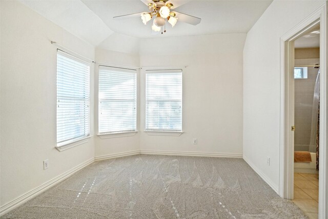 carpeted spare room with a healthy amount of sunlight and lofted ceiling