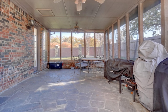 unfurnished sunroom with ceiling fan