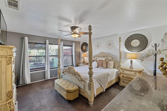 bedroom featuring dark colored carpet, a textured ceiling, and ceiling fan