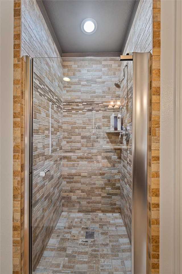 bathroom with a textured ceiling and walk in shower