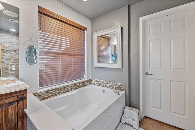 bathroom with tile patterned floors, a washtub, and vanity