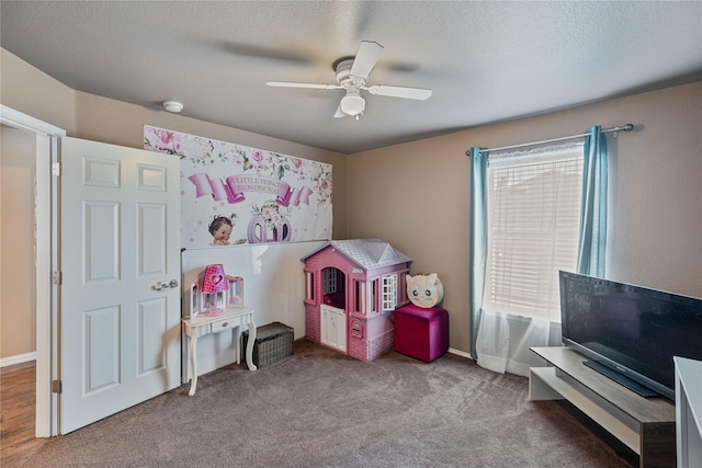 rec room with carpet flooring, a textured ceiling, ceiling fan, and a healthy amount of sunlight