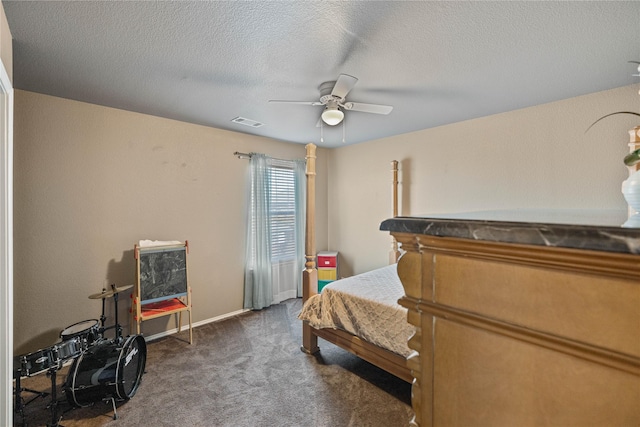 bedroom featuring a textured ceiling, dark carpet, and ceiling fan