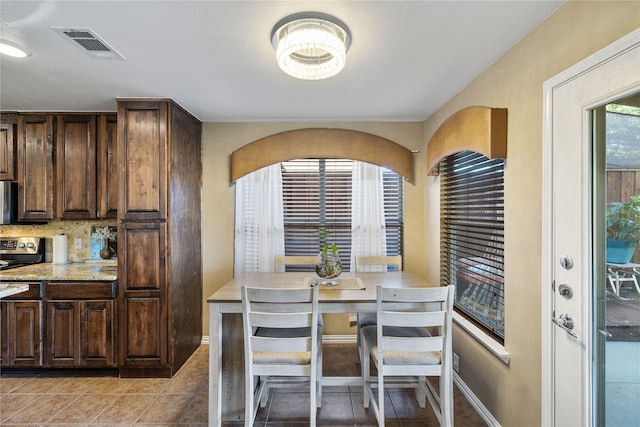 dining room featuring light tile patterned floors and a textured ceiling