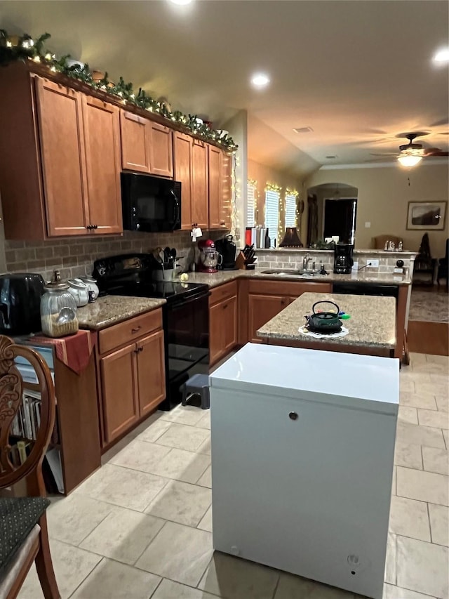 kitchen with black appliances, ceiling fan, a center island, and backsplash