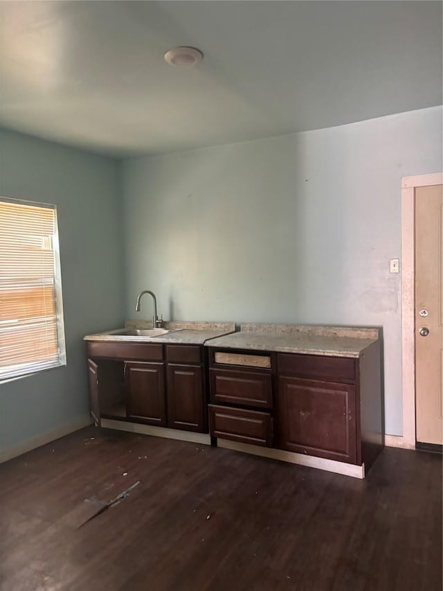 interior space with dark hardwood / wood-style flooring, dark brown cabinets, and sink