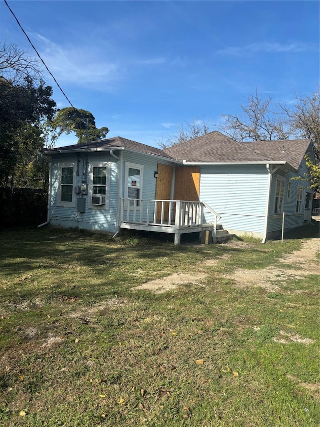 rear view of house with cooling unit, a wooden deck, and a yard