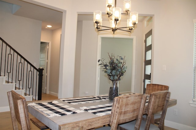 dining space with light wood-type flooring and a notable chandelier