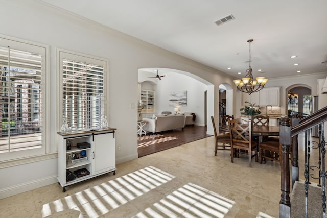 dining room featuring ceiling fan with notable chandelier and ornamental molding