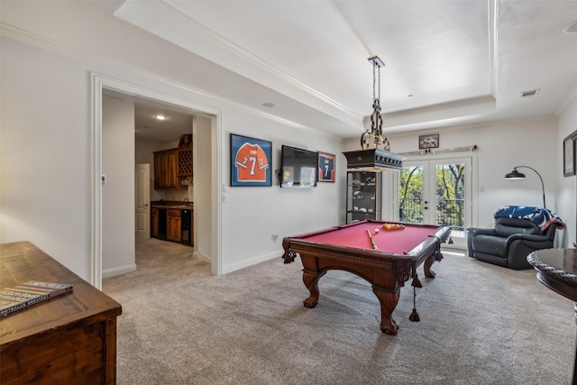 game room with french doors, a raised ceiling, billiards, light colored carpet, and ornamental molding