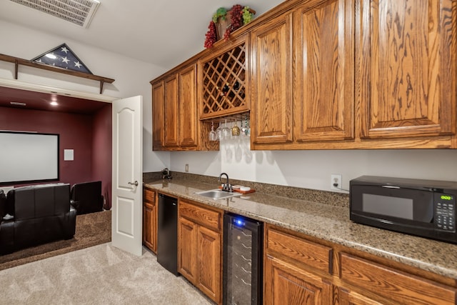 kitchen featuring sink, light stone countertops, light carpet, and beverage cooler