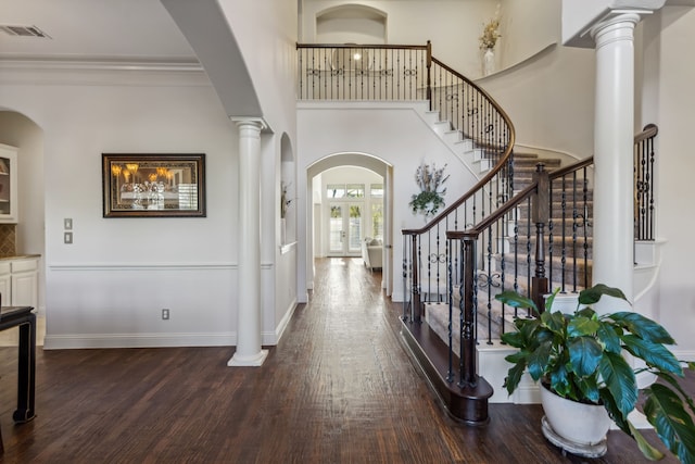 entrance foyer with dark hardwood / wood-style flooring, crown molding, french doors, and a high ceiling