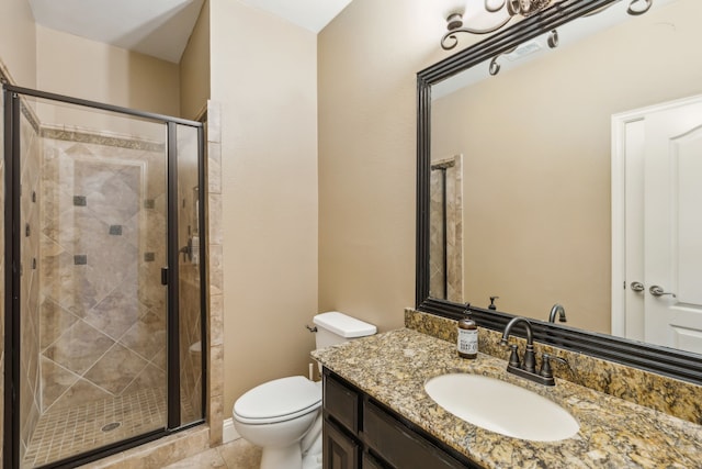 bathroom featuring vanity, a shower with shower door, and toilet