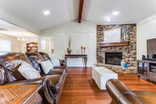 living room featuring vaulted ceiling with beams, a fireplace, dark hardwood / wood-style floors, and a chandelier