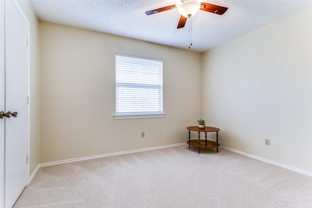 carpeted spare room featuring ceiling fan and a textured ceiling