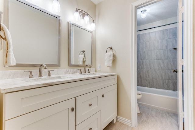 full bathroom featuring vanity, tiled shower / bath, and toilet