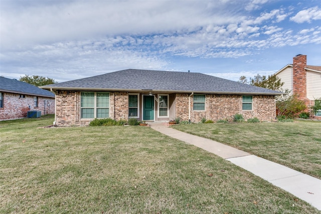 ranch-style house featuring a front lawn and central air condition unit