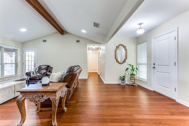 foyer with wood-type flooring, lofted ceiling with beams, and plenty of natural light