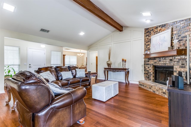 living room featuring a healthy amount of sunlight, a fireplace, hardwood / wood-style floors, and vaulted ceiling with beams