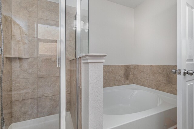 bathroom featuring shower with separate bathtub