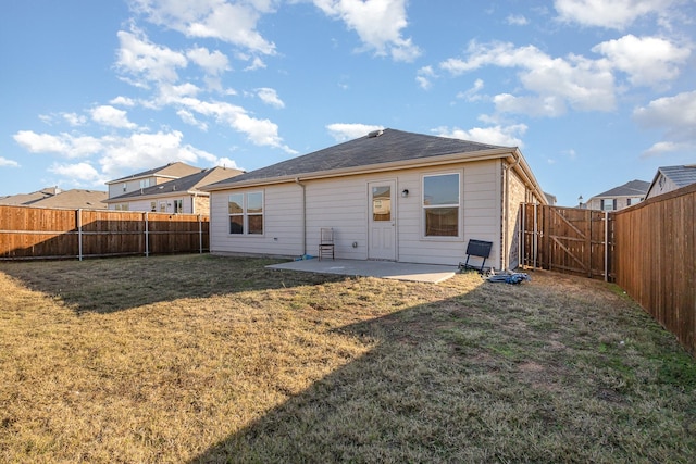 back of house with a lawn and a patio