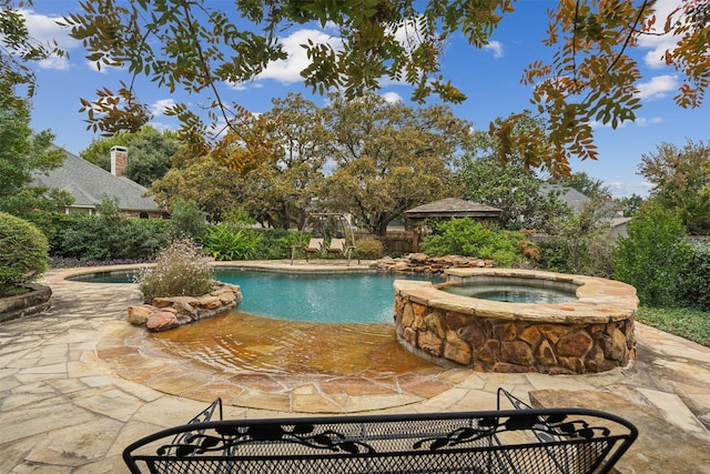 view of pool featuring an in ground hot tub and a patio