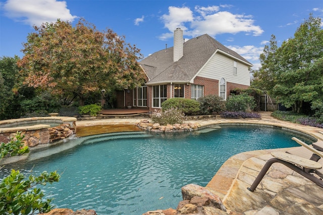 view of pool with an in ground hot tub, pool water feature, and a sunroom