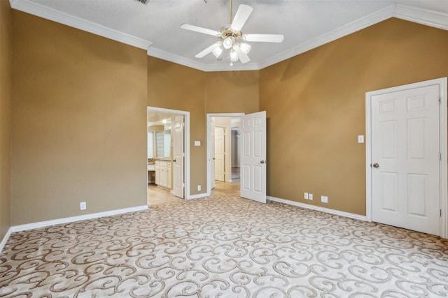 carpeted empty room featuring ceiling fan, high vaulted ceiling, and ornamental molding