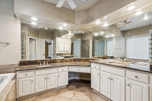 bathroom featuring vanity, tile patterned floors, and tiled tub